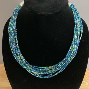 Chico’s beaded necklace beaded in blues, greens and silver with lobster clasp.